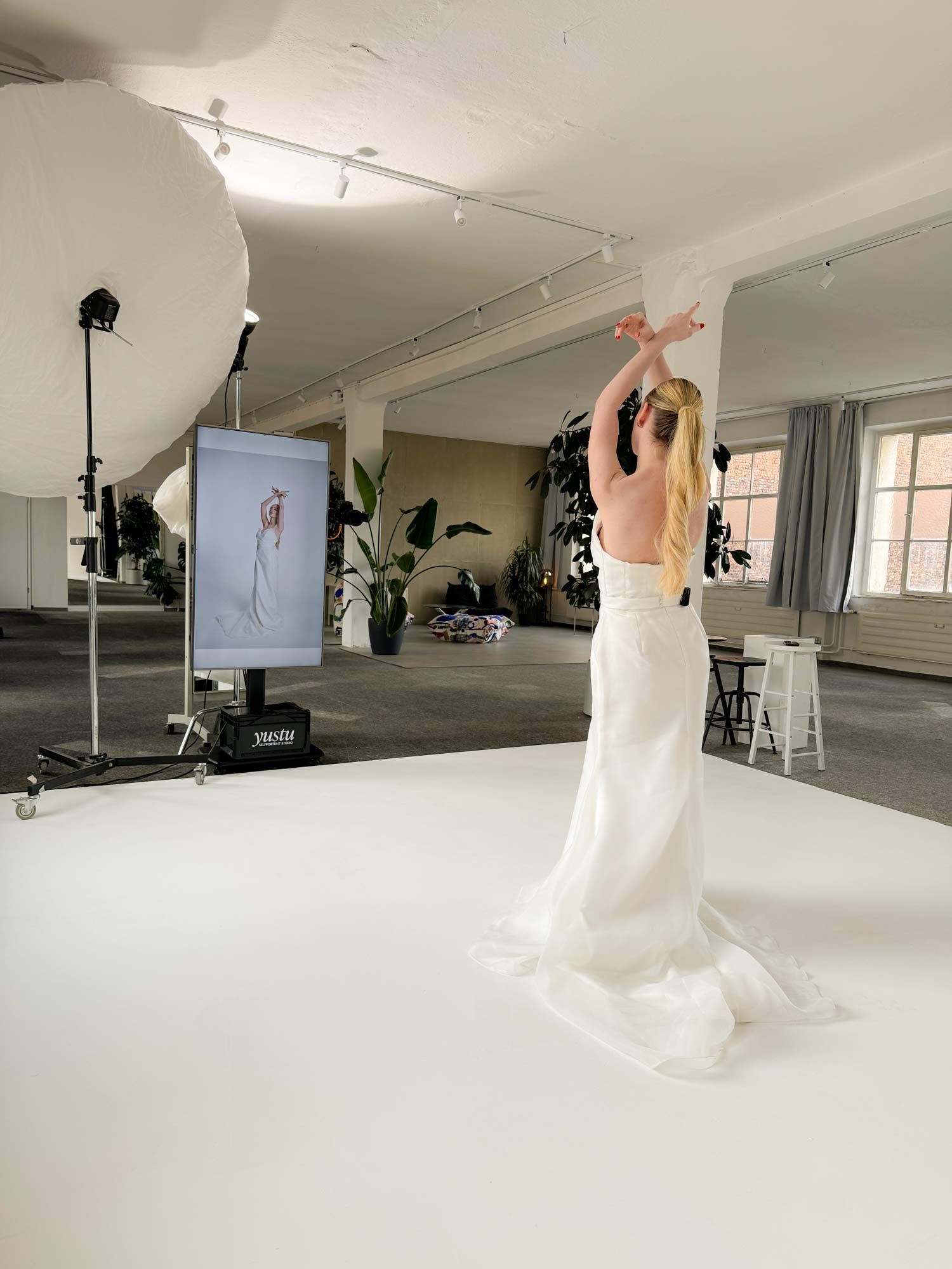 Eine Kundin löst ihr Selbstportrait im professionell beleuchteten yustu Studio aus